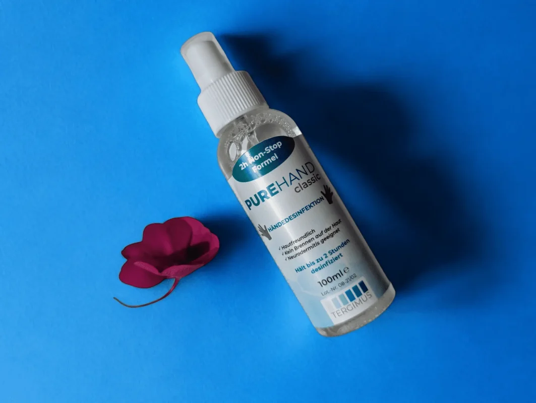 PUREHAND Classic 100 ml Händedesinfektion ohne Alkohol auf blauem Hintergrund