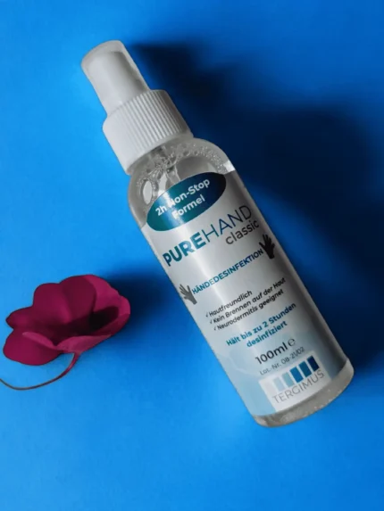 PUREHAND Classic 100 ml Händedesinfektion ohne Alkohol auf blauem Hintergrund