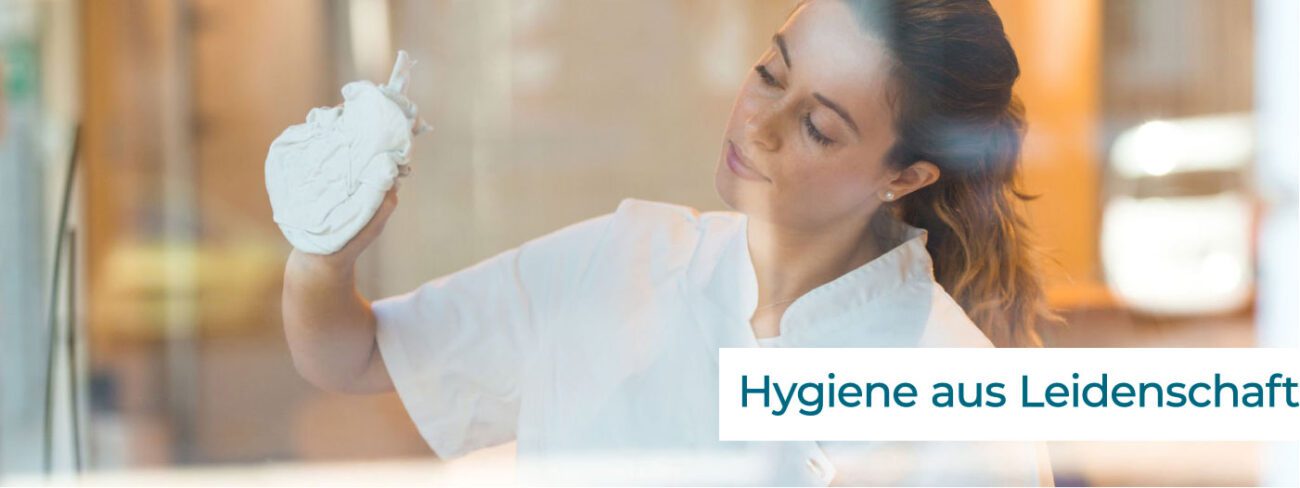 Mitarbeiterin reinigt eine Glasscheibe – Hygiene aus Leidenschaft